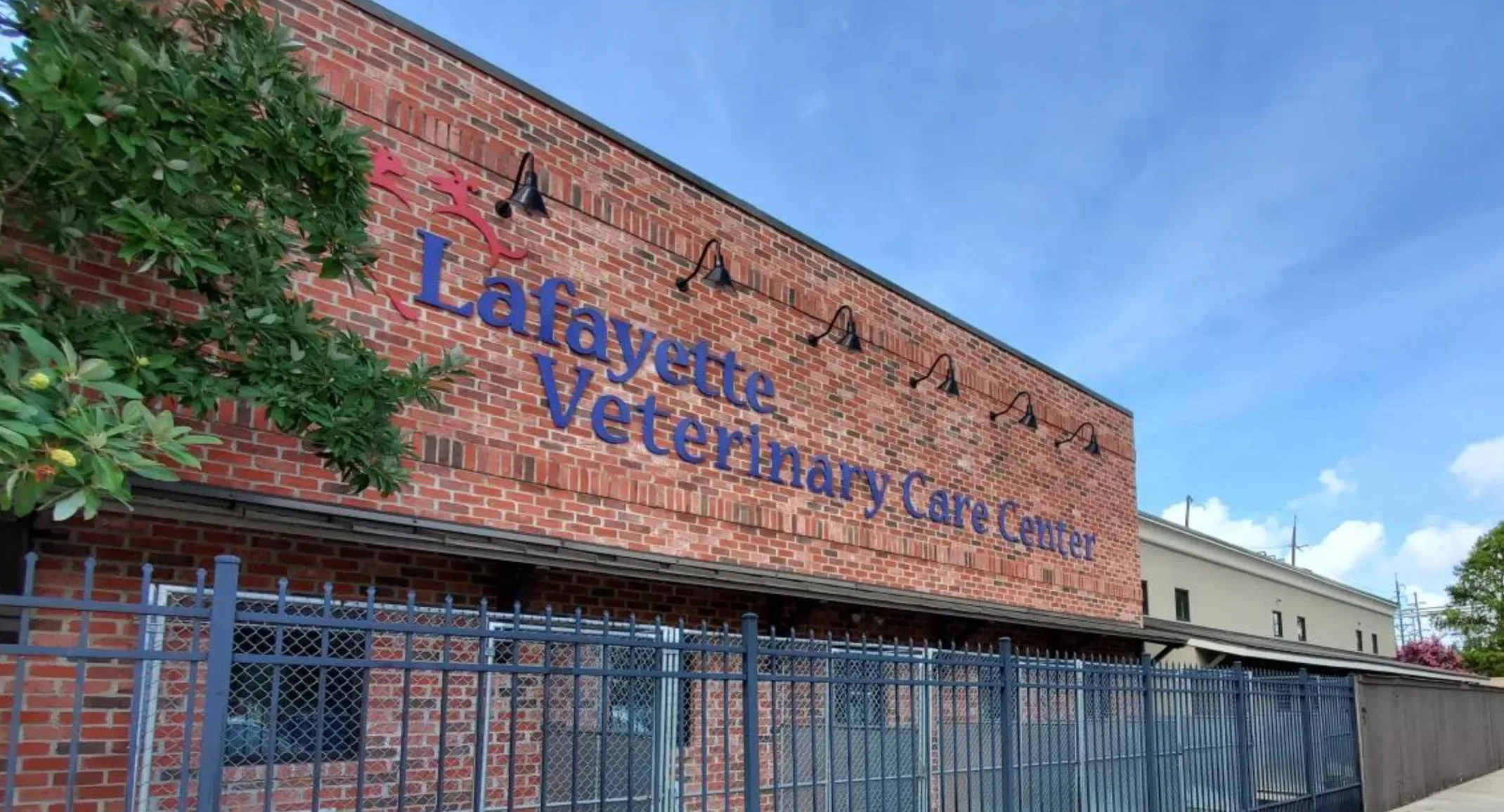Front view of brick building with Lafayette Veterinary Care Center in large blue letters. 